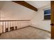 Upper level loft area featuring wood beam, carpet, and natural light at 7054 S Flower Ct, Littleton, CO 80128