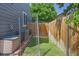 Side yard with artificial grass, chain link fence and an AC unit at 7054 S Flower Ct, Littleton, CO 80128