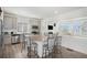Open concept kitchen with stainless steel appliances, island with barstool seating, and direct view to living room at 4108 N Quatar Ct, Aurora, CO 80019