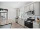 Stylish kitchen is equipped with stainless steel appliances, gray cabinets, and granite countertops at 4108 N Quatar Ct, Aurora, CO 80019