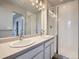 Bathroom featuring a double sink vanity, framed mirrors, and a glass enclosed shower at 4773 Kittredge St, Denver, CO 80239