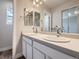 A well-lit bathroom featuring a double sink vanity, framed mirrors, and wood-look floors at 4773 Kittredge St, Denver, CO 80239
