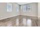 Bright, airy bedroom with hardwood floors and three large windows providing ample natural light at 4773 Kittredge St, Denver, CO 80239