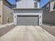 Exterior elevation of house with gray siding, gray garage door and concrete driveway at 4773 Kittredge St, Denver, CO 80239