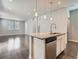 Modern kitchen with island featuring stainless dishwasher, adjacent to spacious living area at 4773 Kittredge St, Denver, CO 80239