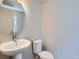 This stylish powder room features a pedestal sink and a toilet, with neutral walls at 4773 Kittredge St, Denver, CO 80239