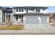 Modern two-story home featuring a three-car garage, stone accents, and a well-manicured lawn at 303 Rogers Ct, Castle Rock, CO 80104