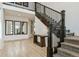 Bright foyer featuring a staircase with dark wood banister and iron balusters, wood floors, and tall ceilings at 303 Rogers Ct, Castle Rock, CO 80104