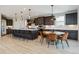 Open kitchen features a large center island with seating, pendant lighting, dining area, and stainless appliances at 303 Rogers Ct, Castle Rock, CO 80104