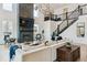 Bright living room featuring a fireplace, large television, and modern staircase at 303 Rogers Ct, Castle Rock, CO 80104