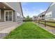 A green backyard with a well-kept lawn and a fenced perimeter, with a view of neighboring homes at 757 Cabot Dr, Erie, CO 80516