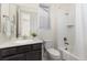 Bright bathroom featuring a shower-tub combo, dark wood vanity, and a neutral color palette at 757 Cabot Dr, Erie, CO 80516