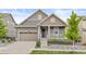 Charming home featuring a landscaped front yard, covered porch, and attached two-car garage at 757 Cabot Dr, Erie, CO 80516