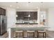 Modern kitchen with a large island, stainless steel appliances, and dark cabinets at 757 Cabot Dr, Erie, CO 80516