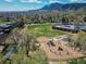 Aerial view of a school with playground set against a mountain backdrop, complemented by sports fields and green spaces at 1172 Juniper Ave, Boulder, CO 80304