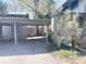 View of a carport attached to a gray home with mature landscaping and visible natural gas meter at 1172 Juniper Ave, Boulder, CO 80304