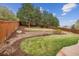 Well-manicured backyard featuring terraced garden beds, a lush lawn, and a wooden privacy fence at 10969 Valleybrook Cir, Highlands Ranch, CO 80130
