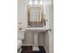 Stylish powder room featuring a pedestal sink, decorative mirror, and black and white tile accents at 10969 Valleybrook Cir, Highlands Ranch, CO 80130