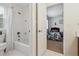 Bathroom showing white shower-tub combo and an open doorway to a bedroom at 10969 Valleybrook Cir, Highlands Ranch, CO 80130