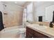 Bathroom features a shower-tub combo, neutral tile, and a wood vanity at 10969 Valleybrook Cir, Highlands Ranch, CO 80130