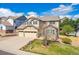 Beautiful two-story home with a well-maintained lawn, three-car garage, and classic architectural details at 10969 Valleybrook Cir, Highlands Ranch, CO 80130