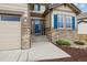 Inviting front entrance with stone accents, a charming welcome sign, and a well-manicured garden bed at 10969 Valleybrook Cir, Highlands Ranch, CO 80130
