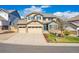 Attractive two-story home with a three-car garage, blue shutters, and a beautifully landscaped front yard at 10969 Valleybrook Cir, Highlands Ranch, CO 80130