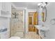 Updated bathroom features a glass enclosed shower, tiled floors, and sleek vanity with a framed oval mirror at 1732 Lansing St, Aurora, CO 80010