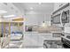 Modern kitchen featuring white cabinets, tile floors, stainless steel appliances, and sunroom views at 1732 Lansing St, Aurora, CO 80010
