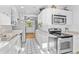 Bright kitchen showcasing stainless steel appliances, white cabinets, and tile flooring at 1732 Lansing St, Aurora, CO 80010