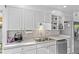 Well-lit kitchen with white cabinetry, stainless steel appliances, and tile backsplash at 1732 Lansing St, Aurora, CO 80010