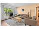 Bright and airy living room showcasing ample natural light, a comfortable sofa, hardwood floors and a large picture window at 1732 Lansing St, Aurora, CO 80010