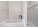Bathroom with a white tub and tiled surround, complemented by a glass-enclosed shower with tiled walls at 6001 S Yosemite St # F207, Greenwood Village, CO 80111