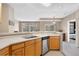 Well-lit kitchen features modern stainless-steel dishwasher, wooden cabinets and breakfast bar at 6001 S Yosemite St # F207, Greenwood Village, CO 80111