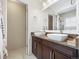Double sink vanity with vessel sinks, dark cabinets, granite counters, and tile floors at 7323 Lowell Blvd, Westminster, CO 80030
