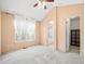 Bedroom with an en suite bathroom, carpeted floors, a ceiling fan, and a large window at 7323 Lowell Blvd, Westminster, CO 80030