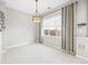 Dining area illuminated by a modern chandelier, featuring neutral walls, window, and tile flooring at 7323 Lowell Blvd, Westminster, CO 80030