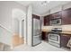 Modern kitchen featuring stainless steel appliances, dark wood cabinets, and white tile floor at 7323 Lowell Blvd, Westminster, CO 80030