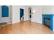 Open-concept living area with hardwood floors and view of blue fireplace and half-bath at 7323 Lowell Blvd, Westminster, CO 80030