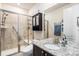 Well-lit bathroom with a glass-enclosed shower, granite vanity, and a mirrored medicine cabinet at 13326 Olive Way, Thornton, CO 80602