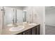 Bathroom with dual sinks, an expansive mirror, and dark cabinetry, offering plenty of space and storage at 13326 Olive Way, Thornton, CO 80602