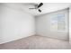 Bright, empty bedroom with neutral carpet and walls, with a window view of the outside at 13326 Olive Way, Thornton, CO 80602