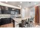 Well-designed kitchen with dark cabinets, granite countertops, a tiled backsplash, and modern pendant lighting at 13326 Olive Way, Thornton, CO 80602