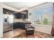 Charming kitchen featuring dark cabinets, stainless steel appliances, hardwood floors, and a view of the yard at 13326 Olive Way, Thornton, CO 80602