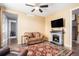 Cozy living room featuring a stone fireplace, ceiling fan, and comfortable seating at 13326 Olive Way, Thornton, CO 80602