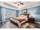 Cozy main bedroom with blue walls, tray ceiling, a ceiling fan, and a large window for natural light at 13326 Olive Way, Thornton, CO 80602