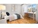 Bright bedroom with hardwood floors, a built-in desk, and modern minimalist art at 5231 Quitman St, Denver, CO 80212