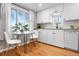 Charming kitchen featuring white cabinetry, hardwood floors, and a cozy breakfast nook at 5231 Quitman St, Denver, CO 80212