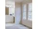 Carpeted bedroom with a bathroom suite featuring white cabinets and bright windows at 11867 Elk Head Range Rd, Littleton, CO 80127
