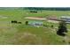 Aerial view of single-story home nestled among grassy, open range with horse arena at 27115 County Road 13, Elizabeth, CO 80107
